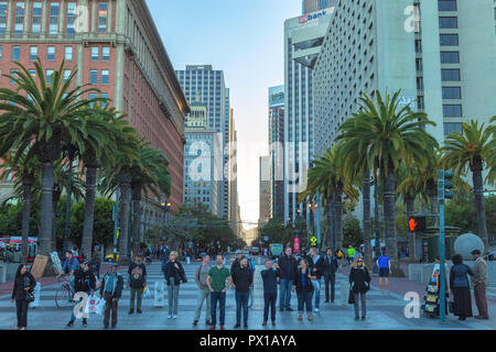Fußgänger warten an der Ampel mit San Francisco Downtown im Hintergrund, Kalifornien, USA, bei Sonnenuntergang. Stockfoto