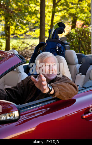 Gut Rentner fährt mit seinem Cabrio zu seinem Golfspiel, USA Stockfoto