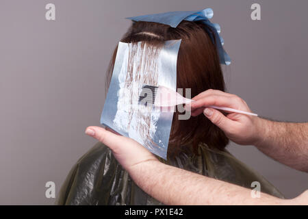 Professionelle Friseur holding Pinsel und färben die Haare ihrer Kunden. Studio erschossen. auf weißem Hintergrund. Stockfoto