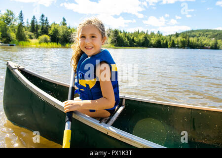 Glückliches Kind genießen Kanufahrt auf schönen Fluss Stockfoto