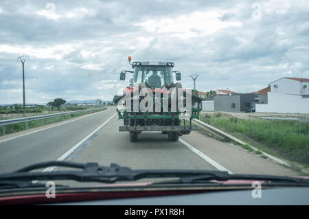 Langsam Fahren hinter einem Traktor durch die Straße. Fahren mit durchgezogene Linie Stockfoto