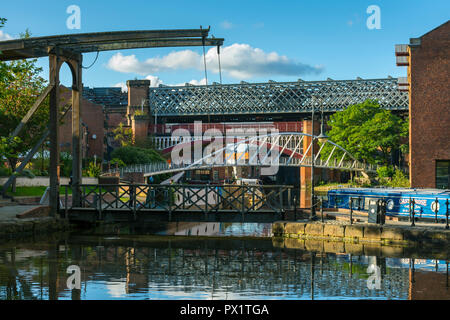 Ein klapp Fußgängerbrücke, die Kaufleute und viktorianischen Bahnhof Viadukte aus dem mittleren Lager Becken, Castlefield, Manchester, England, Großbritannien Stockfoto