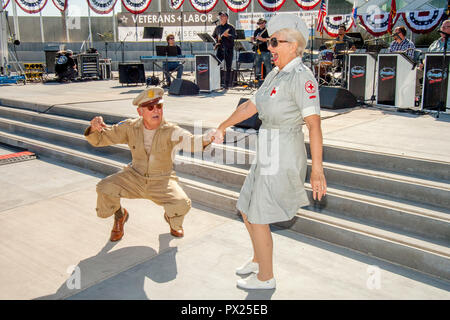 Ein Weltkriegveteran in US Army uniform und eine Frau, gekleidet wie ein rotes Kreuz freiwillige glücklich Tanz der jutterbug am Veterans Day Feier in Costa Mesa, CA. Stockfoto