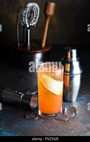 Orange gin Cocktail mit einer dünnen Scheibe Gurke Stockfoto