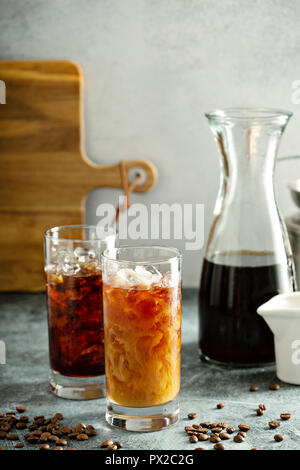 Erfrischende kalte Gebräu Eiskaffee in hohe Gläser mit Milch oder Kaffeesahne Stockfoto