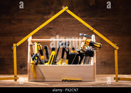 Haus Aus Maßband über Toolbox mit verschiedenen Worktools Stockfoto