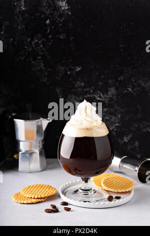 Irish Coffee in einem Cocktail Glas mit Schlagsahne Stockfoto