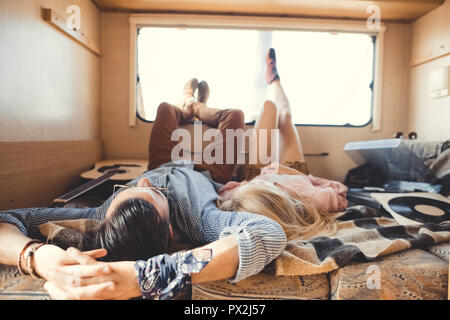 Hippie Paar liegen im Wohnmobil mit akustischer Gitarre und Vinyl player Stockfoto