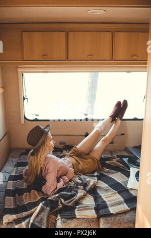 Hippie girl in hat Lügen im Reisemobil mit Schallplatten Stockfoto