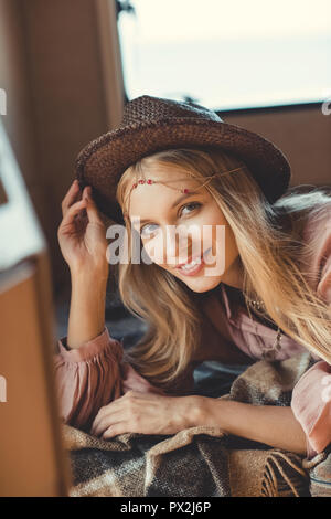 Attraktive hippie Girl in hat liegt im Inneren des Anhängers Stockfoto