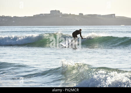 Newquay, Cornwall, England. September 2018. Ein männlicher Paddle Boarding über Watergate Bay Beach an einem sonnigen Nachmittag im Herbst Stockfoto