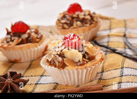 Cupcakes mit Kirsche und Mandel Blütenblätter Stockfoto