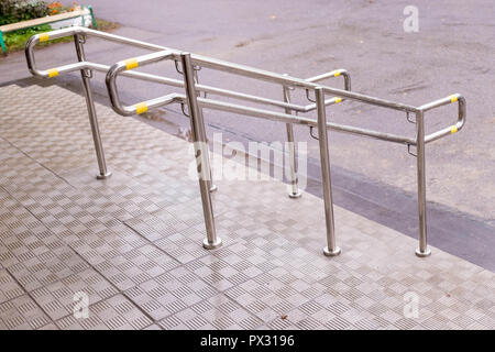 Edelstahl Handläufe sind an den Wänden und Schritten installiert. Stahl Geländer. Hilfe für Menschen mit eingeschränkter Mobilität, für ältere Menschen. Platz kopieren. treppenschacht mit metallischen Treppe Geländer außerhalb des Gebäudes Stockfoto