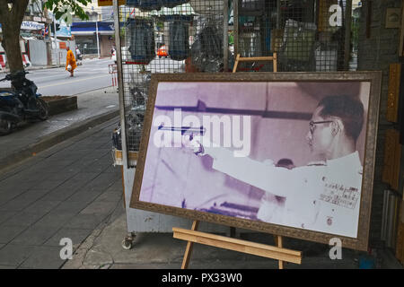 Ein Geschäft in der Nähe von zahlreichen Waffenläden in Bangkok zeigt ein seltenes Foto von ehemaligen thailändische König Bhumipol Adulyadej, in seiner Jugend ein begeisterter Sport Scharfschütze Stockfoto