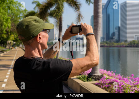 Senior touristische Mann mit Kappe während der Bilder bei friedlichen Stockfoto