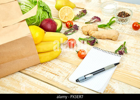 Einkaufsliste, Rezeptbuch, Diätplan. Grocering Konzept. Full Paper bag verschiedener Früchte und Gemüse Zutaten für gesundes Kochen auf einem Woo Stockfoto