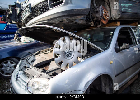 19 Oktober 2018, Nordrhein-Westfalen, Bottrop: 19. Oktober 2018, Deutschland, Bottrop: ein Rad Deckel mit VW Logo unterstützt eine Motorhaube eines VW Golf Wrack auf einem Schrottplatz. Im Kampf gegen die drohende Fahrverbote, Volkswagen will jetzt zurück zu nehmen und alte Dieselmotoren mit der Euro 1 zu 4 Emissionsstandards bundesweit gegen Rabatte Schrott. Foto: Marcel Kusch/dpa Stockfoto