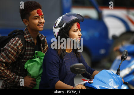 Dharan, Nepal. Okt, 2018 19. Nepalesische mit Tika auf die Stirn aufgetragen einen Roller während Tika, am zehnten Tag des Dashain Festival in Kathmandu, Nepal am Freitag, 19 Oktober, 2018 Fahrt. Die Ältesten, tika und jamara auf der Stirn der jüngeren Verwandten sie mit dem Überfluss in den kommenden Jahren zu segnen. Vijaya Dashami symbolisiert den Sieg des Guten über das Böse und ist die größte und längste Festival der nepalischen Hindus betrachtet. Credit: Skanda Gautam/ZUMA Draht/Alamy leben Nachrichten Stockfoto