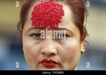 Dharan, Nepal. Okt, 2018 19. Eine nepalesische Frau mit Tika auf die Stirn während Tika, am zehnten Tag des Dashain Festival in Kathmandu, Nepal am Freitag, 19. Oktober 2018 geht. Die Ältesten, tika und jamara auf der Stirn der jüngeren Verwandten sie mit dem Überfluss in den kommenden Jahren zu segnen. Vijaya Dashami symbolisiert den Sieg des Guten über das Böse und ist die größte und längste Festival der nepalischen Hindus betrachtet. Credit: Skanda Gautam/ZUMA Draht/Alamy leben Nachrichten Stockfoto