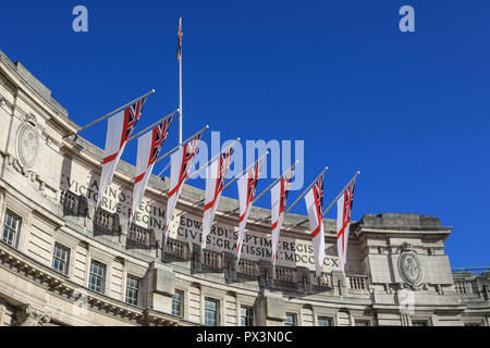 Die Mall, London, UK, 19. Okt 2018. Admiralty Arch sieht Regal gegen den strahlend blauen Himmel im warmen Sonnenschein, mit weißen Fahne Fahnen fliegen. Credit: Imageplotter Nachrichten und Sport/Alamy leben Nachrichten Stockfoto