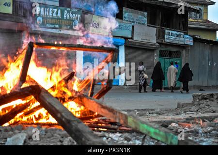 Srinagar, Kashmir. Okt 2018 19. Bewohner gesehen sind Sie an einem brennenden Barrikade von der Kaschmirischen Demonstranten bei Zusammenstößen. Auseinandersetzungen ausgebrochen, nachdem Kerben der Jugend ein Protest gegen die Tötung von zwei Aufständischen und eine zivile während einer Pistole - Schlacht am Freitag Nachmittag nach dem Gebet auf einen Protest von Separatisten gegeben inszeniert. Credit: Saqib Majeed/SOPA Images/ZUMA Draht/Alamy leben Nachrichten Stockfoto