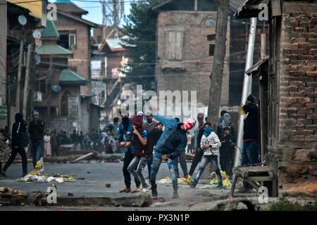 Srinagar, Kashmir. Okt 2018 19. Kaschmir Demonstranten gesehen werden, die Steine gegen die Regierungstruppen bei Zusammenstößen. Auseinandersetzungen ausgebrochen, nachdem Kerben der Jugend ein Protest gegen die Tötung von zwei Aufständischen und eine zivile während einer Pistole - Schlacht am Freitag Nachmittag nach dem Gebet auf einen Protest von Separatisten gegeben inszeniert. Credit: Saqib Majeed/SOPA Images/ZUMA Draht/Alamy leben Nachrichten Stockfoto
