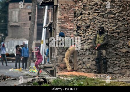 Srinagar, Kashmir. Okt 2018 19. Eine paramilitärische Trooper gesehen seine Waffe auf der Kaschmir Demonstranten bei Zusammenstößen. Auseinandersetzungen ausgebrochen, nachdem Kerben der Jugend ein Protest gegen die Tötung von zwei Aufständischen und eine zivile während einer Pistole - Schlacht am Freitag Nachmittag nach dem Gebet auf einen Protest von Separatisten gegeben inszeniert. Credit: Saqib Majeed/SOPA Images/ZUMA Draht/Alamy leben Nachrichten Stockfoto