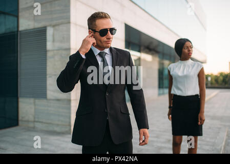 Leibwächter bei Sonnenbrillen und schwarz Business Woman Stockfoto