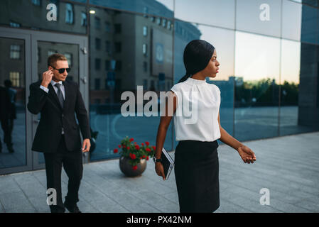 Business Woman, Leibwächter in Anzug auf Hintergrund Stockfoto