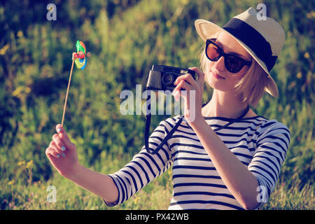 Eine schöne junge Frau Tourist ist ein Bild von einem Wirbelwind Spielzeug mit einer Kamera Stockfoto