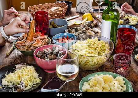 Abendessen mit der Familie Auswahl an italienischen Gerichten mit Glas Weißwein auf hölzernen Tisch. Glückliche Gesellschaft zu Mittag essen, wobei Salatteller. Close Up, Abendessen Tabl Stockfoto