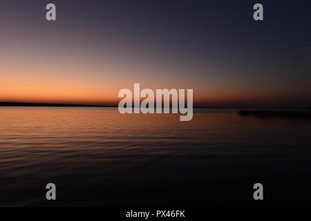 Linien der Farbpalette von Dunkelheit und Licht der Dämmerung Himmel vor Einbruch der Dunkelheit über den See Stockfoto