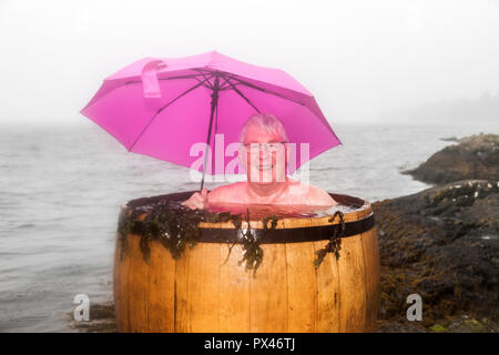 Snave Pier, Ballylickey, Bantry, Co Cork, Irland. 19 August, 2018. Mike Keohane, von Bantry genießen die warme Algenbäder im Regen auf Snav Stockfoto