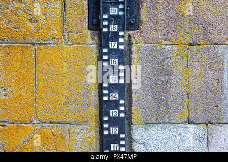 Pegelmessung an die Mauer aus Stein in der Nähe des Flusses befestigen Stockfoto