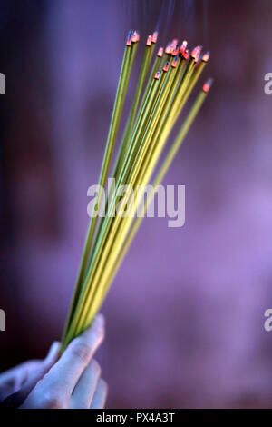 Buddhistische Pagode. Betende Frau mit dem Rauchen Räucherstäbchen. Close-up. Ho Chi Minh City. Vietnam. Stockfoto