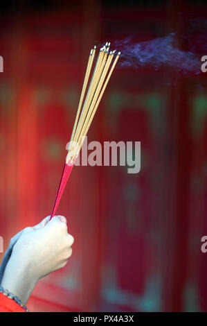 Buddhistische Pagode. Betende Frau mit dem Rauchen Räucherstäbchen. Close-up. Ho Chi Minh City. Vietnam. Stockfoto