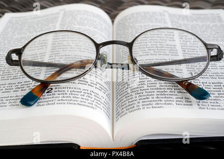 Brille auf eine offene Bibel. Stockfoto