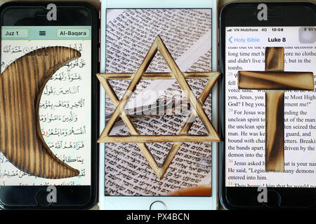 Jüdische, christliche und muslimische Kreuz und Halbmond, religiöse Symbole von Christentum, Islam, Judentum auf 3 Smartphones mit digitalen App. Stockfoto