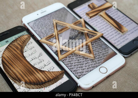 Jüdische, christliche und muslimische Kreuz und Halbmond, religiöse Symbole von Christentum, Islam, Judentum auf 3 Smartphones mit digitalen App. Stockfoto