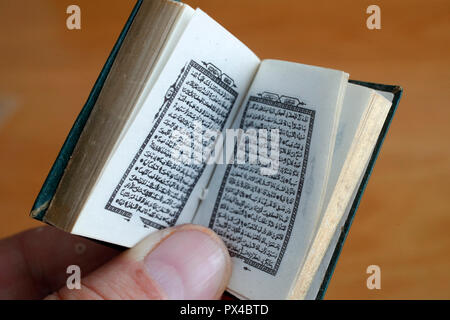 Mann Lesen eines Mini Quran. Stockfoto