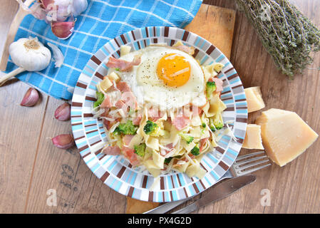 Bandnudeln mit Brokkoli, Schinken und Spiegelei Stockfoto