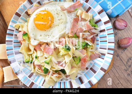 Bandnudeln mit Brokkoli, Schinken und Spiegelei Stockfoto