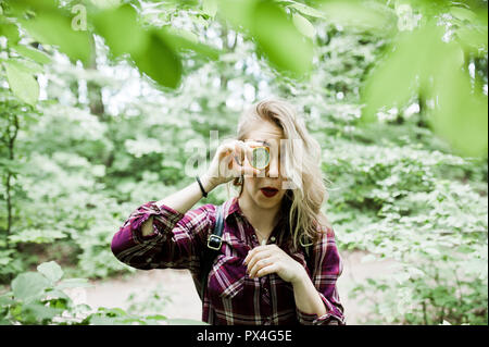 Portrait von eine attraktive blonde Mädchen mit einem Kompass in einem Wald posieren. Stockfoto