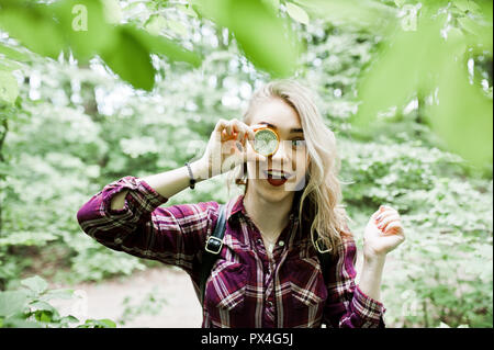 Portrait von eine attraktive blonde Mädchen mit einem Kompass in einem Wald posieren. Stockfoto