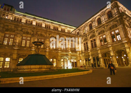 Die berühmte Staatsoper mit Touristen und Besucher zu Fuß vor dem Gebäude bei Nacht. Im Zentrum der Stadt Wien, Österreich befindet, Euro Stockfoto