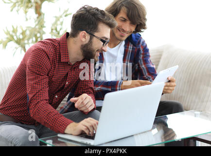 Zwei glückliche Web Designer arbeiten am Laptop im Büro Stockfoto