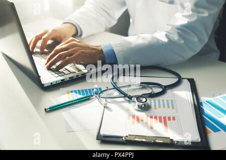 Arzt arbeiten mit Medizinische Statistik und finanzielle Berichte in Office Stockfoto