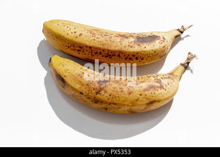 Eine Nahaufnahme von zwei reife, gelbe Bananen nebeneinander auf einem isolierten weißen Hintergrund Stockfoto