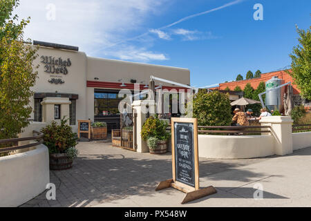 Asheville, NC, USA -10/17/18: Die Veterans Memorial in Pack Square, mit einer jungen Frau neben der Skulptur einer Frau sitzt. Stockfoto