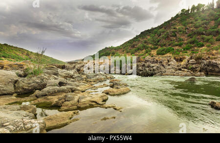 Rio Guadiana, zwischen den Felsen und Bergen mit dem bewölkten Himmel im Hintergrund Stockfoto